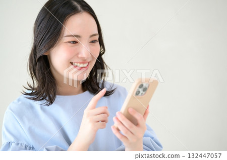 一位憂心忡忡的日本女性正看著她的智慧型手機 132447057