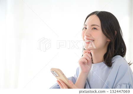 A worried Japanese woman looking at her smartphone A worried Japanese woman looking at her smartphone 132447069