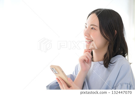 一位憂心忡忡的日本女性正看著她的智慧型手機 132447070