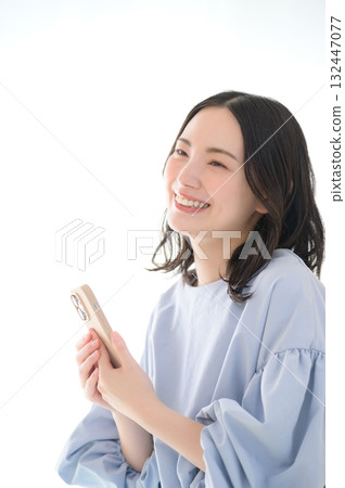A worried Japanese woman looking at her smartphone A worried Japanese woman looking at her smartphone 132447077