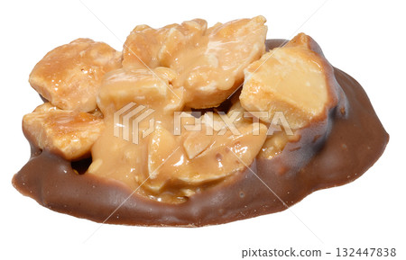 Traditional macadamia nut tartlet candy in caramel on a milk chocolate base Traditional macadamia nut tartlet candy in caramel on a milk chocolate base 132447838
