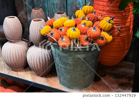 Mini velvet pumpkins in warm orange and yellow tones arranged in a rustic metal bucket. Thanksgiving crafts, cozy seasonal decor, soft sculpture accents, autumn home styling Mini velvet pumpkins in warm orange and yellow tones arranged in a rustic metal bucket. Thanksgiving crafts, cozy seasonal decor, soft sculpture accents, autumn home styling 132447919
