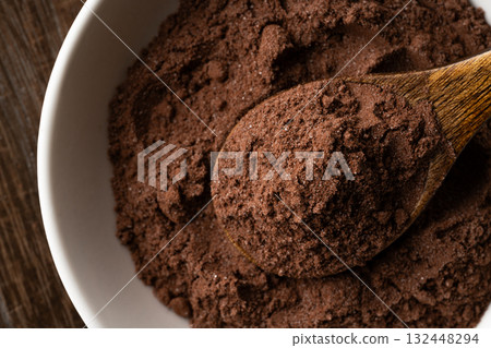 Close-up of cocoa powder with sugar in a spoon on a small plate Close-up of cocoa powder with sugar in a spoon on a small plate 132448294