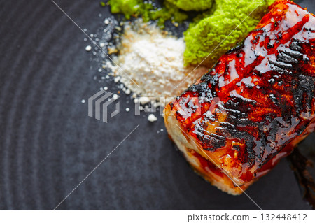 Grilled smoked eel on black plate Grilled smoked eel on black plate 132448412