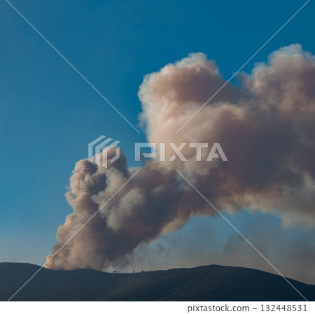 Large Plume of Smoke Over Mountain Landscape 132448531