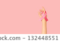 International symbol of Breast Cancer Awareness Month in October. Close up of female hand holding satin pink ribbon awareness on pink background. Women's health care and medical concept. 132448551