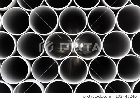 gray PVC tubes plastic pipes stacked in rows 132449240