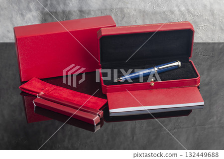 A signature fountain pen on a gray marble background. A box and case are nearby. A signature fountain pen on a gray marble background. A box and case are nearby. 132449688
