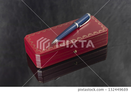A signature fountain pen on a gray marble background. A box and case are nearby. A signature fountain pen on a gray marble background. A box and case are nearby. 132449689