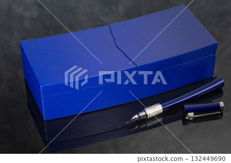 A signature fountain pen on a gray marble background. A box and case are nearby. A signature fountain pen on a gray marble background. A box and case are nearby. 132449690