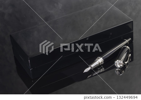 A signature fountain pen on a gray marble background. A box and case are nearby. A signature fountain pen on a gray marble background. A box and case are nearby. 132449694