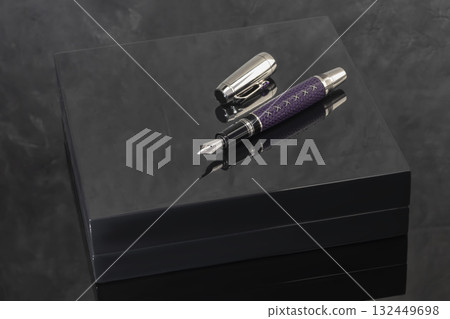 A signature fountain pen on a gray marble background. A box and case are nearby. 132449698