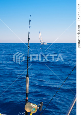 fishing boat trolling in ocean with golden reel 132449886