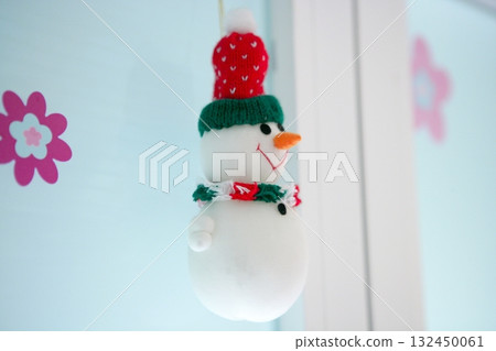 snowman hanging on the white window 132450061