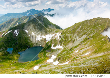 mountain landscape with alpine lake in summer. beautiful pond near popular hiking trail through transylvania alps of fagaras massif. postcard from romania on a sunny day. popular destination of europe mountain landscape with alpine lake in summer. beautiful pond near popular hiking trail through transylvania alps of fagaras massif. postcard from romania on a sunny day. popular destination of europe 132450450