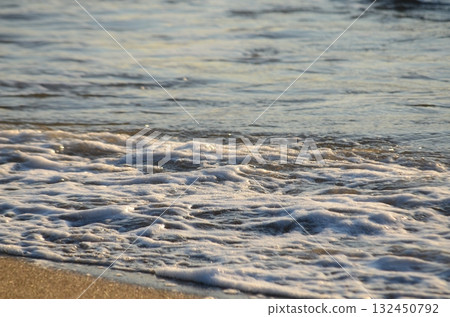 黃昏時分，海面上波光粼粼，平靜的水面沐浴在柔和的光線中 132450792