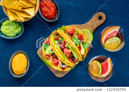 Meat tacos and Paloma cocktails, with nachos and salsas, Mexican food and drink 132450795