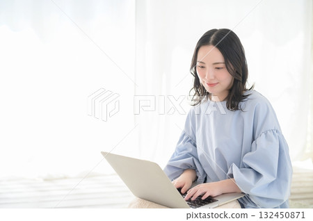 A Japanese woman operating a personal computer 132450871