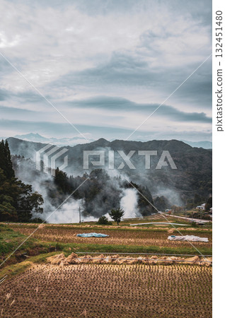 Post-harvest rice paddies and smoke from field burning [Ooka, Nagano City] 132451480
