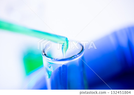 A drop of liquid drips from a pipette into a chemical tube A drop of liquid drips from a pipette into a chemical tube 132451804