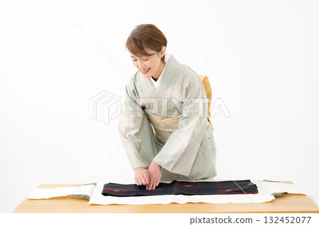 Woman folding kimono recycling 132452077