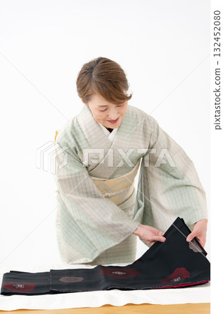 Woman folding kimono recycling Woman folding kimono recycling 132452080