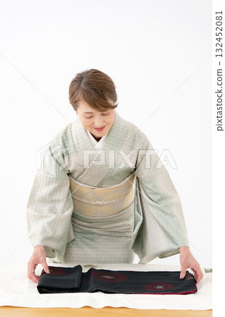 Woman folding kimono recycling 132452081