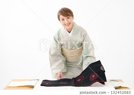 Woman folding kimono recycling Woman folding kimono recycling 132452083