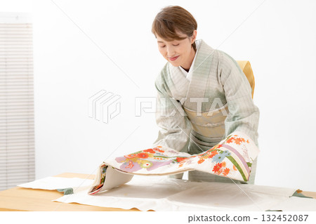 Woman folding kimono recycling Woman folding kimono recycling 132452087