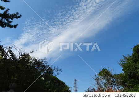 Clouds floating in the autumn sky. A steel tower in the distance 132452203