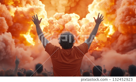 A Crowd Celebrating with Arms Raised Amidst Dramatic Fireworks Explosion in Orange Sky 132452923