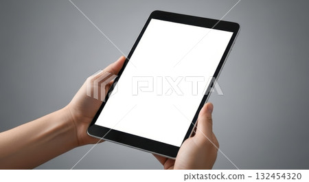 Person holding blank tablet against gray background for mockup or design presentation 132454320