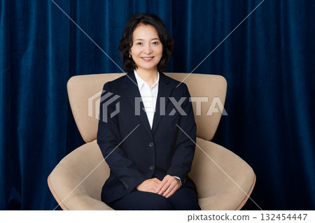 Middle-aged businesswoman sitting on a large chair 132454447