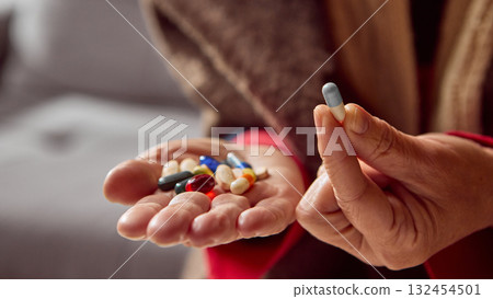 Elderly woman holding single capsule with pills on palm for selection Elderly woman holding single capsule with pills on palm for selection 132454501