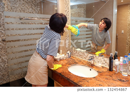 A housewife woman washes a large mirror in the bathroom 132454867
