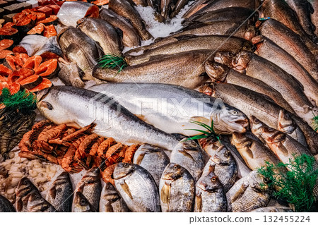 Large assortment of fish and seafood are displayed in a market. Large assortment of fish and seafood are displayed in a market. 132455224
