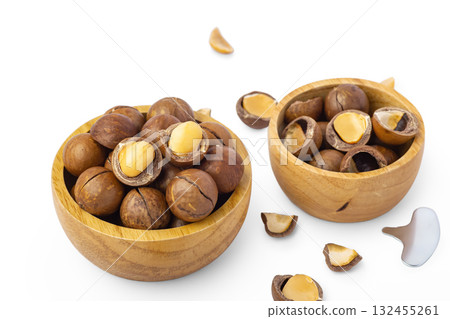 Macadamia nuts in wood bowls with broken macadamia and tool isolated on white background Macadamia nuts in wood bowls with broken macadamia and tool isolated on white background 132455261