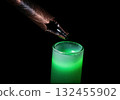 Damaged copper pipette tip over glowing green liquid in scientific test tube. 132455902