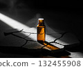 Amber glass bottle of essential oil on textured stone with dramatic lighting 132455908