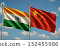 Flags of India and China waving in wind against blue sky with clouds, symbolizing international relations and diplomacy 132455986