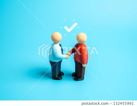 Two people shake hands to signify an agreement. To reach agreement, consensus. Business partnership, cooperation, and trust-building during negotiations or contract signing. 132455991