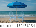 Relaxing beach scene featuring two clear plastic chairs under blue umbrella, with gentle waves lapping at shore 132456134