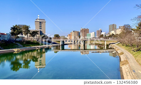 The blue sky and cityscape reflected in the water of the Otsu River (view of Sakurajo Bridge from Meidai Bridge/Okazaki City, Aichi Prefecture) The blue sky and cityscape reflected in the water of the Otsu River (view of Sakurajo Bridge from Meidai Bridge/Okazaki City, Aichi Prefecture) 132456380