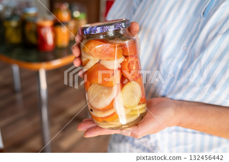 Homemade pickled vegetables in glass jar held by female adult. National Pickle Day Homemade pickled vegetables in glass jar held by female adult. National Pickle Day 132456442