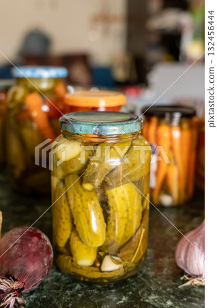 Homemade pickles and vegetables in jars on kitchen table. National Pickle Day Homemade pickles and vegetables in jars on kitchen table. National Pickle Day 132456444