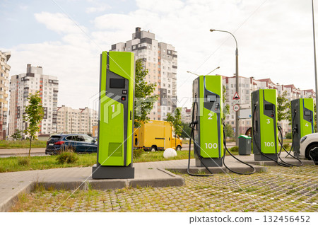 Green electric vehicle charging stations in urban residential area with modern buildings Green electric vehicle charging stations in urban residential area with modern buildings 132456452