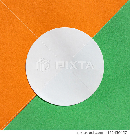 Minimalist circular white paper on orange and green diagonal background Minimalist circular white paper on orange and green diagonal background 132456457