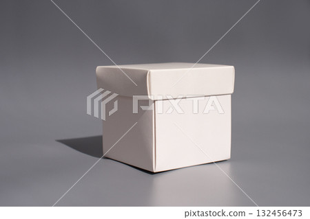 Minimalist white gift box on gray background in soft lighting Minimalist white gift box on gray background in soft lighting 132456473