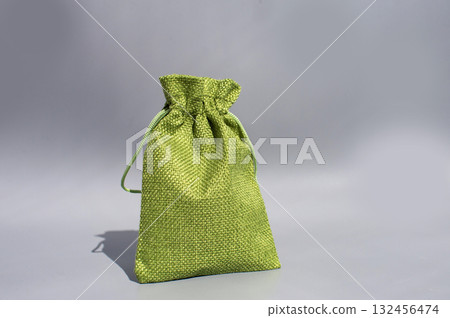 Green textured drawstring bag on gray background - eco-friendly fabric pouch Green textured drawstring bag on gray background - eco-friendly fabric pouch 132456474