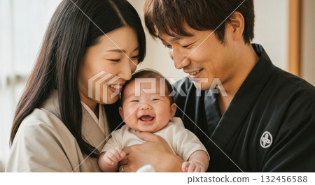 A young couple and their baby smiling happily 132456588